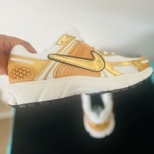 Brand New Nike Vomero 5 Metallic Gold Tennis Shoes 
Size 8. 5 Women’s